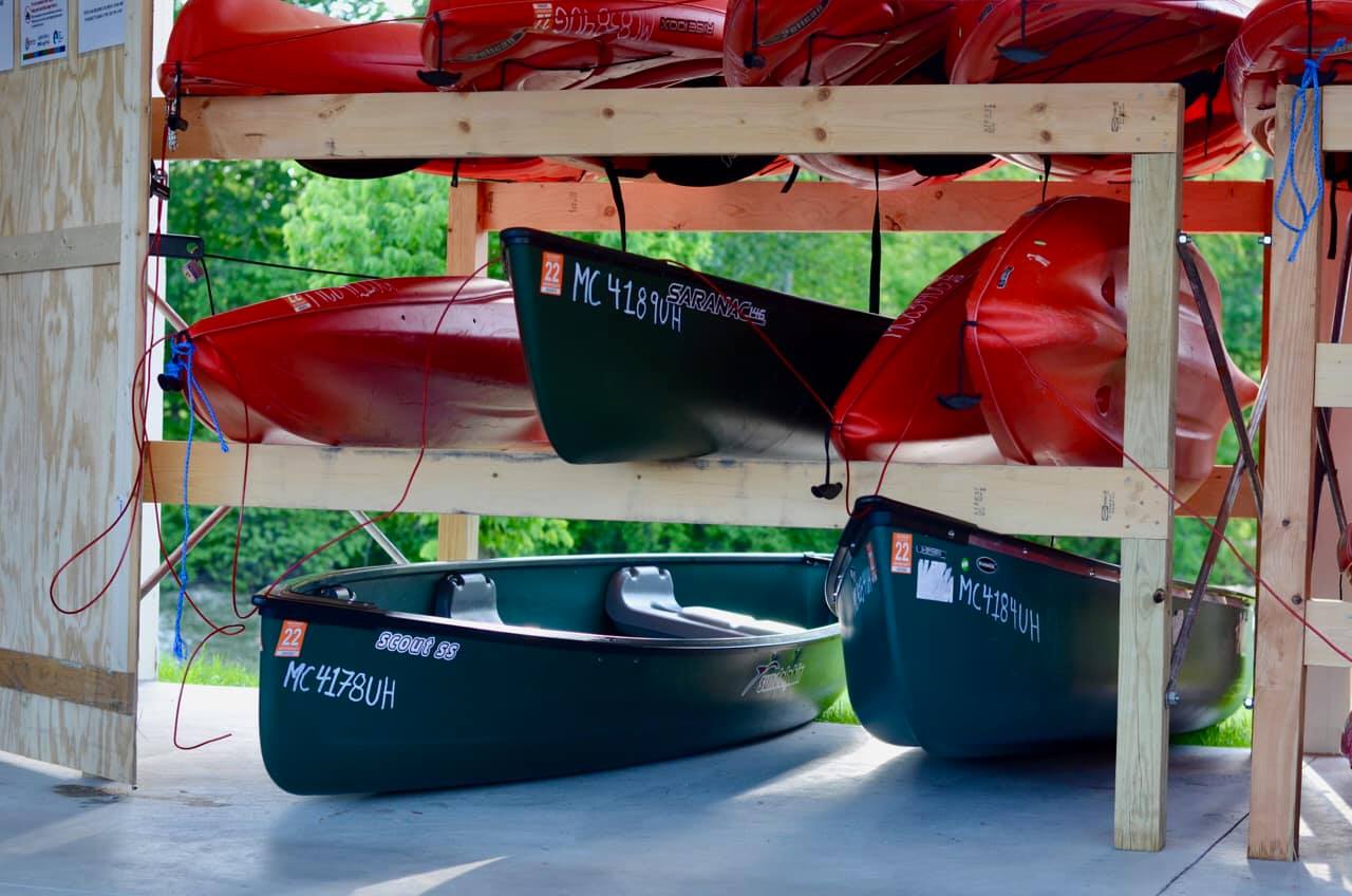 Colorful rack of kayaks ready for rental at Atwater Paddles in Flat Rock, MI.